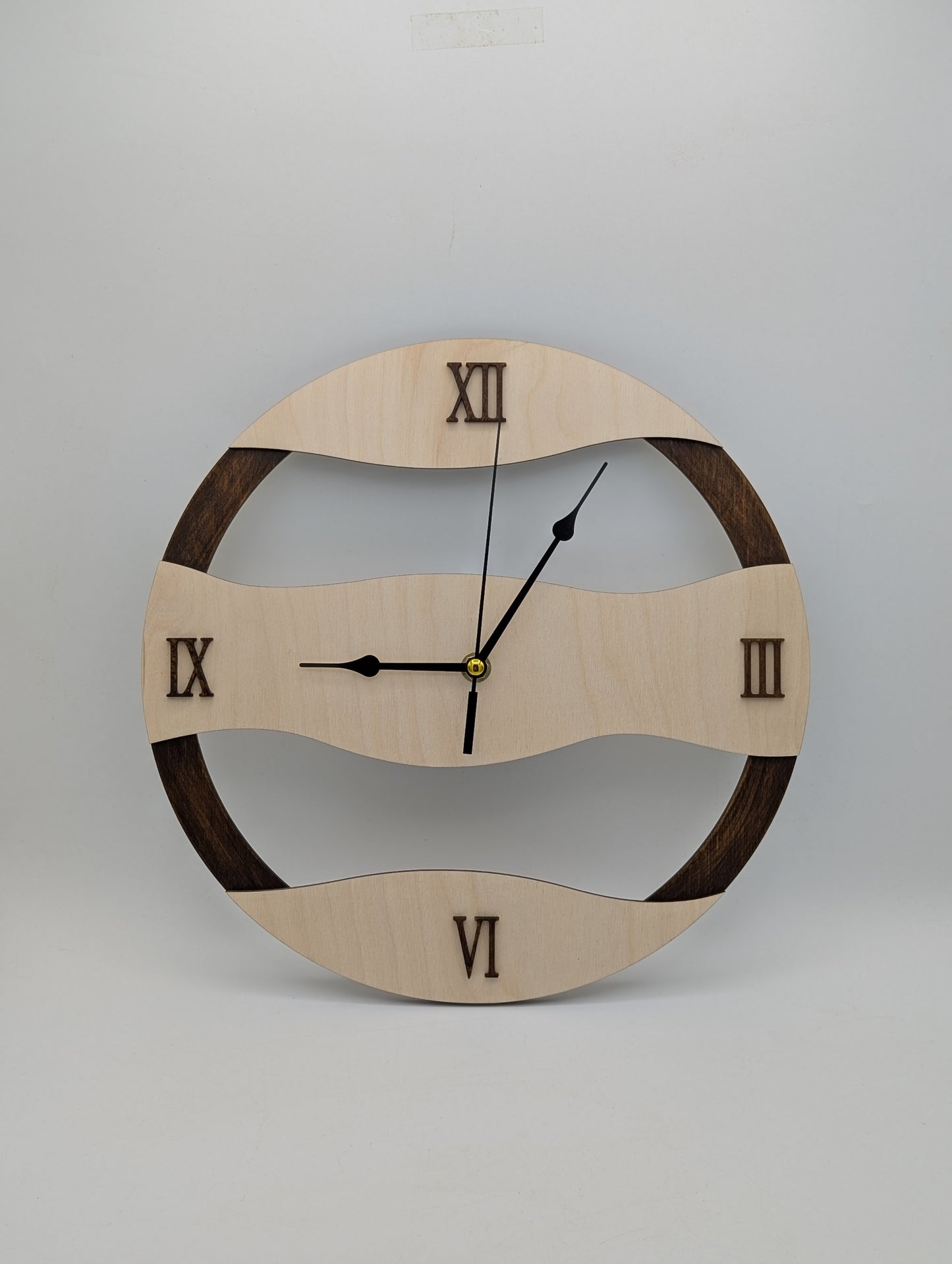 Frontansicht der handgefertigten Wanduhr mit wellenförmigem hell-dunkel Birkenholz-Design