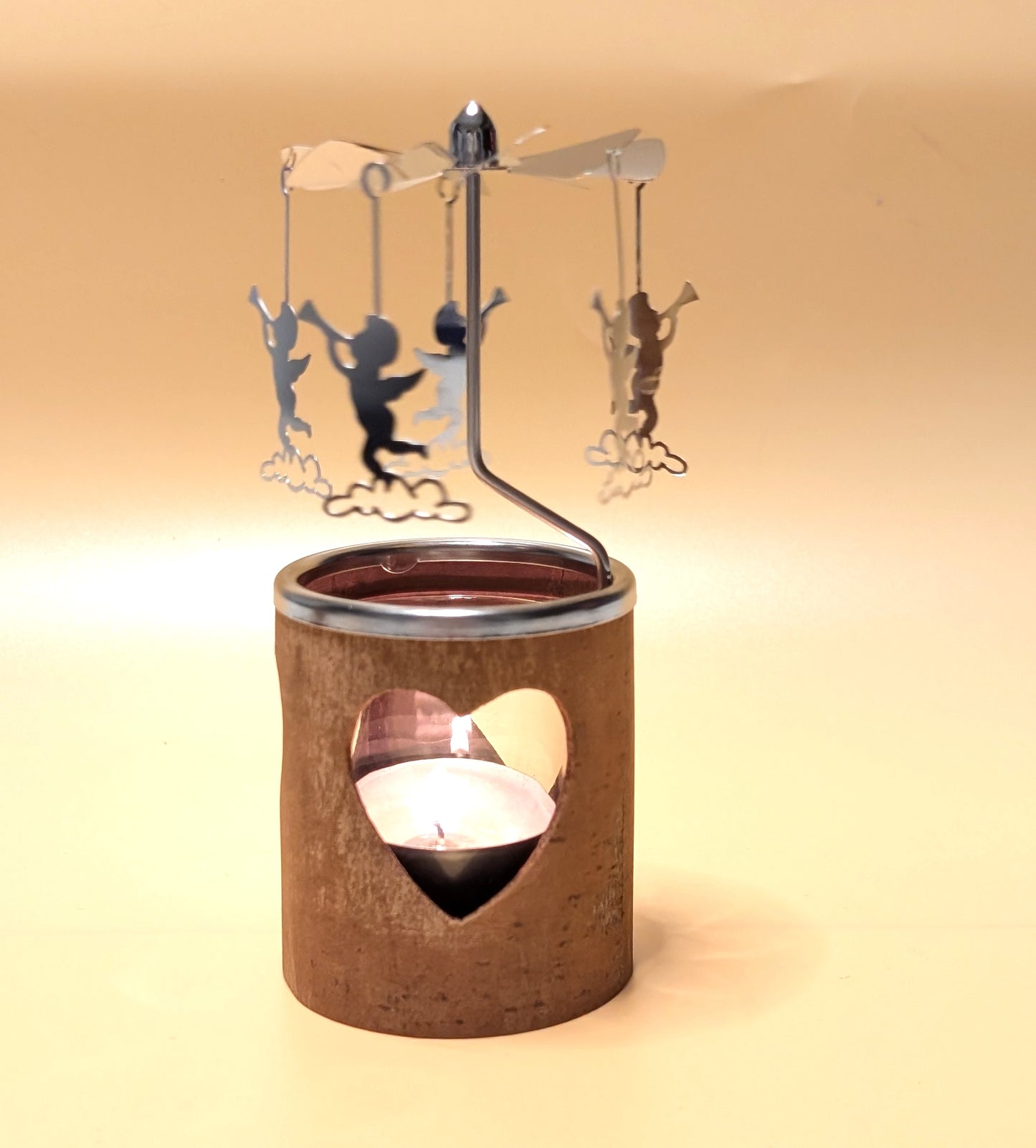 Kerzenkarussell mit natürlichem Zimtrinden-Teelichthalter, Glaseinsatz und rotierenden Metallanhängern, wahlweise mit Herz- oder Tannenbaum-Motiv.