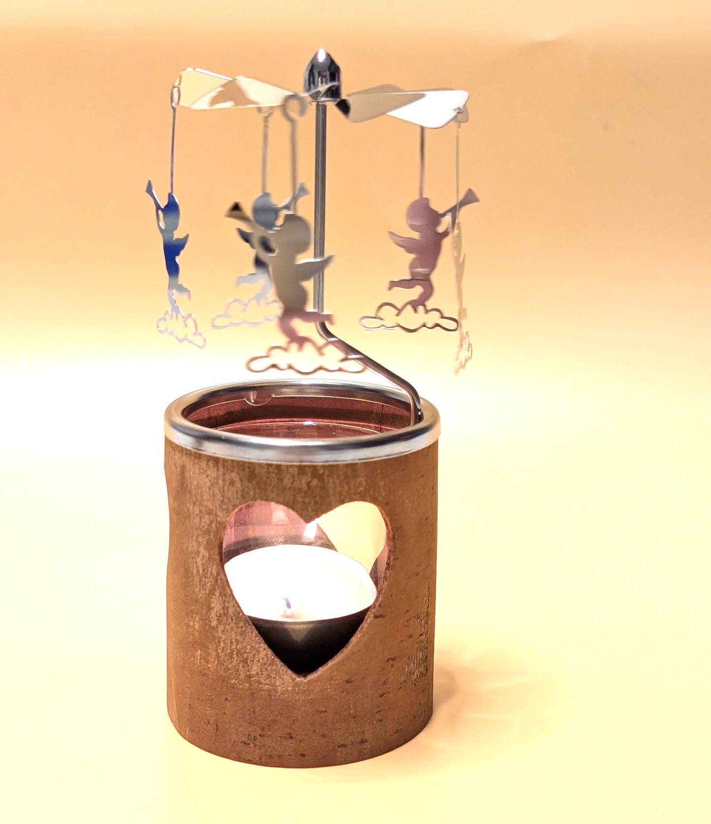 Kerzenkarussell mit natürlichem Zimtrinden-Teelichthalter, Glaseinsatz und rotierenden Metallanhängern, wahlweise mit Herz- oder Tannenbaum-Motiv.