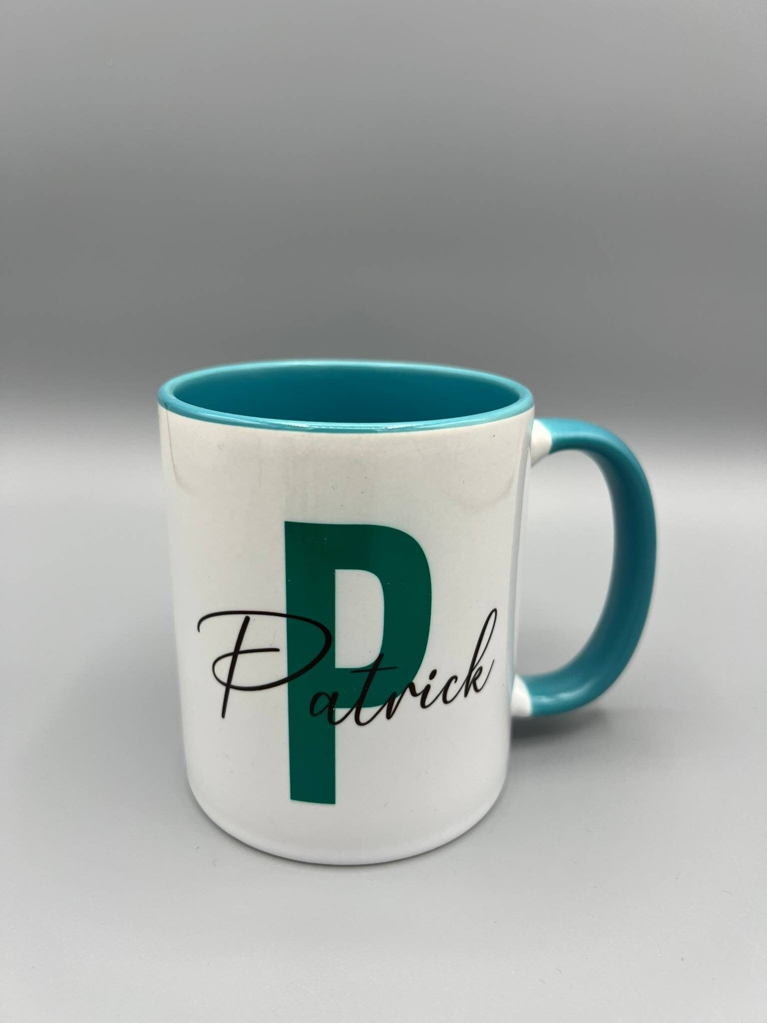 Personalisiert bedruckte Keramiktassen mit Buchstaben und Namen in verschiedenen Farben.