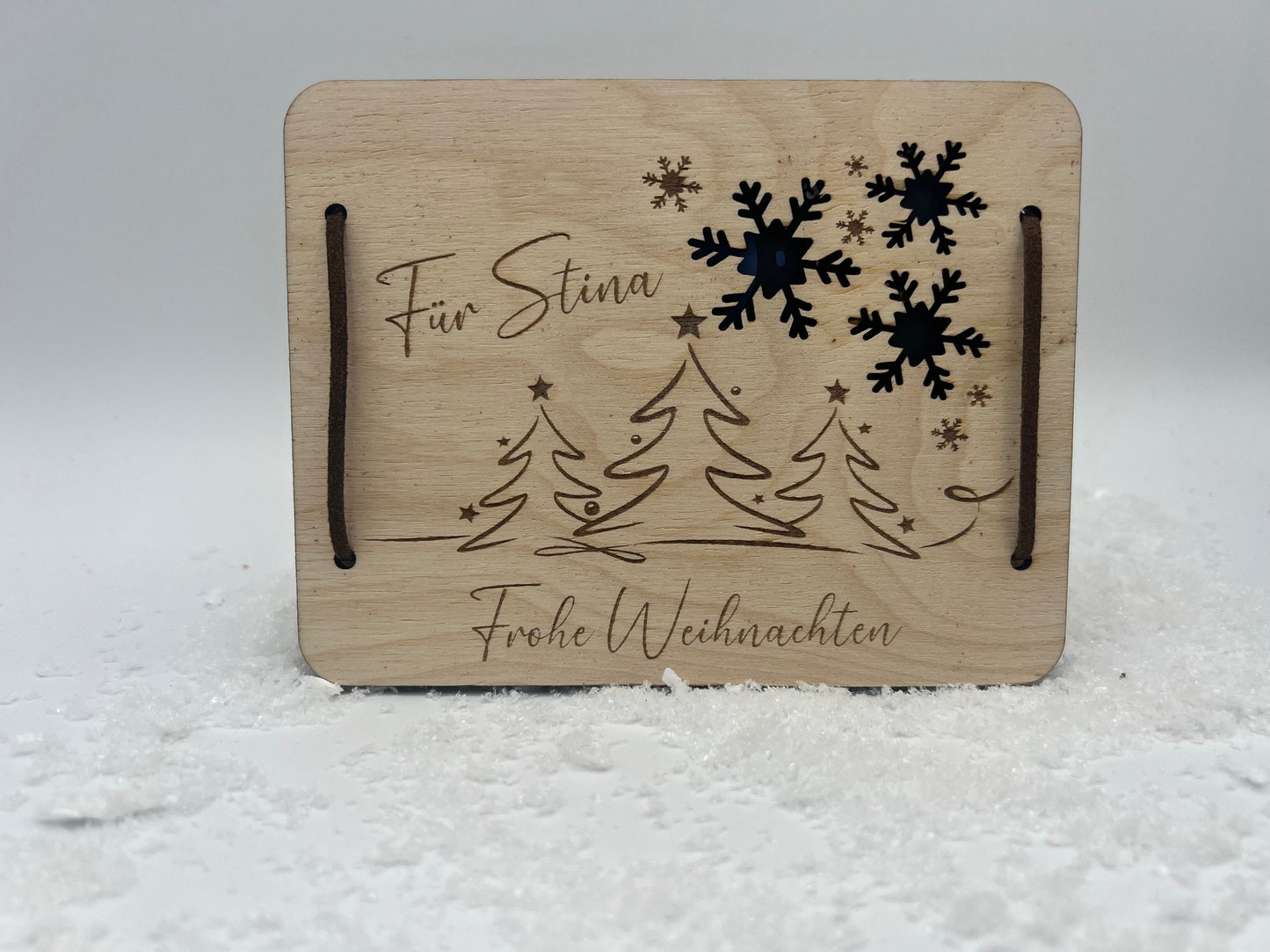 Gutscheinkarte aus Holz, mit einer lasergravur im weihnachtsmotiv. Zum verschließen liegen 2 Leder Bänder bei