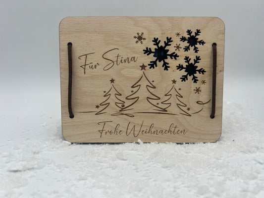 Gutscheinkarte aus Holz, mit einer lasergravur im weihnachtsmotiv. Zum verschließen liegen 2 Leder Bänder bei