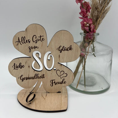 Holz-Kleeblatt als Geldgeschenk, wahlweise in 12,5 cm oder 18 cm Größe. Mit eingravierter Jahreszahl (z. B. 18, 30, 40, 50, 60, 66, 70, 80) oder individueller Wunschzahl. Perfekt als Glücksbringer zum Geburtstag, Jubiläum oder besonderen Anlässen. Geldscheine können dekorativ befestigt werden