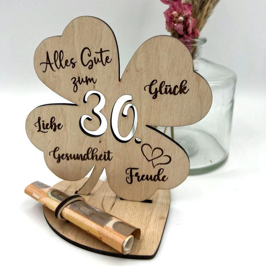 Holz-Kleeblatt als Geldgeschenk, wahlweise in 12,5 cm oder 18 cm Größe. Mit eingravierter Jahreszahl (z. B. 18, 30, 40, 50, 60, 66, 70, 80) oder individueller Wunschzahl. Perfekt als Glücksbringer zum Geburtstag, Jubiläum oder besonderen Anlässen. Geldscheine können dekorativ befestigt werden